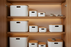 White storage boxes with rounded bottoms in pantry